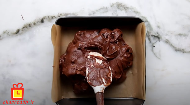 ریختن مواد براونی در قالب در طرز تهیه براونی شکلاتی و خیس