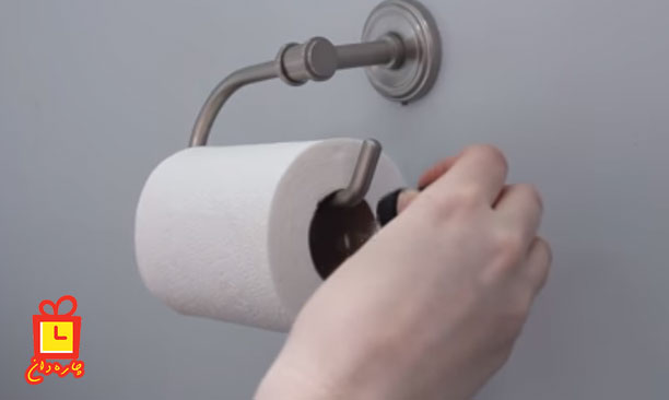 چکاندن قطره عطر روی دستمال توالت برای خوشبو کردن توالت